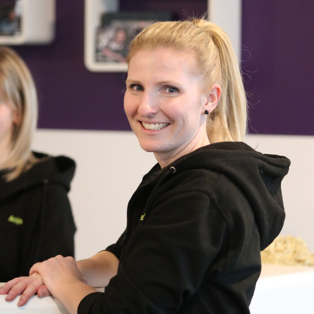 Mitarbeiterin und Physiotherapeutin von aktiv physio lächelt.